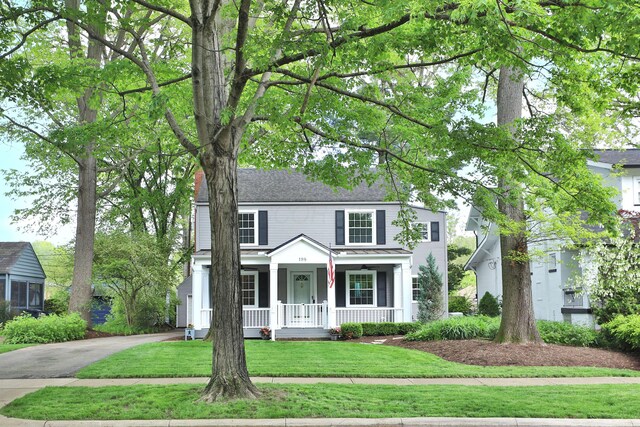 view of front of house featuring covered porch and a front lawn
