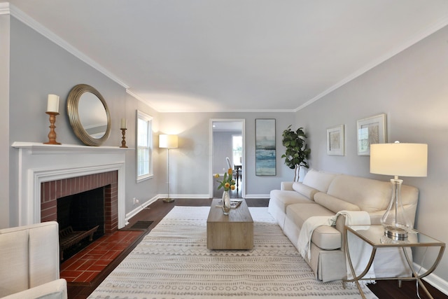 living area with ornamental molding, baseboards, wood finished floors, and a brick fireplace