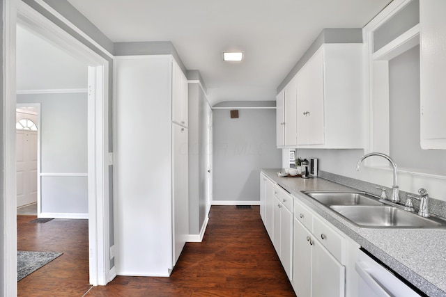 kitchen with a sink, white dishwasher, white cabinetry, and light countertops