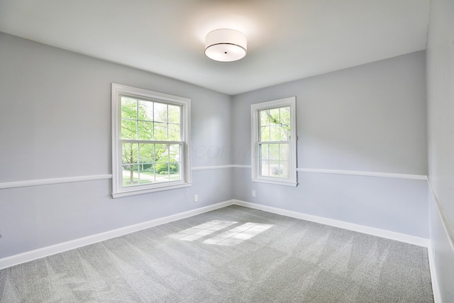 carpeted spare room featuring baseboards