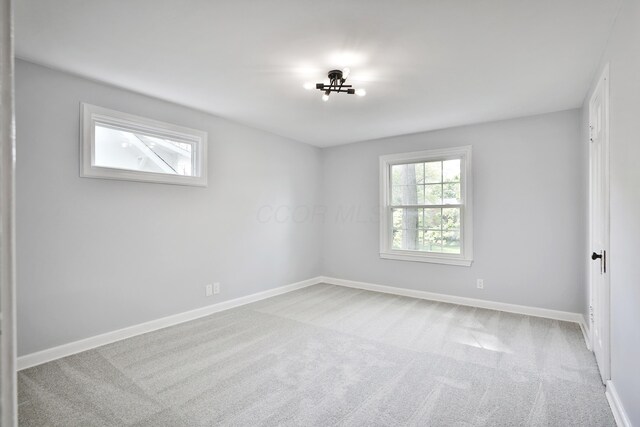 unfurnished room with carpet and baseboards