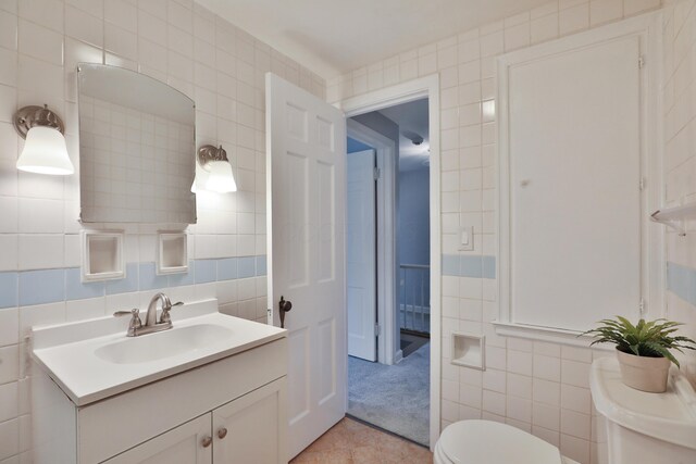 bathroom featuring tile walls, toilet, tile patterned flooring, and vanity