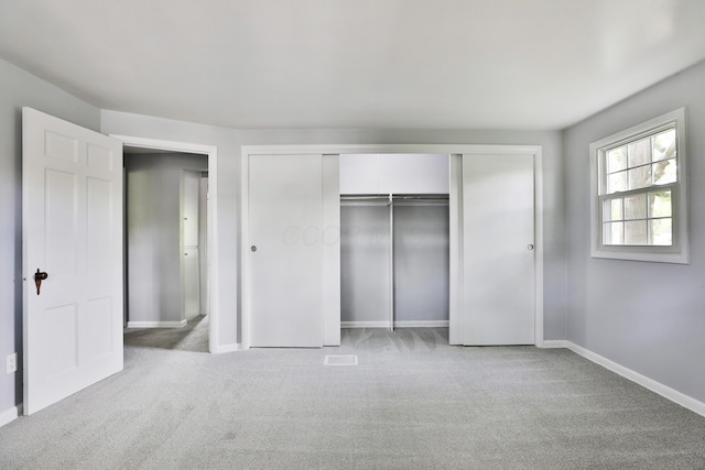 unfurnished bedroom with carpet, a closet, and baseboards