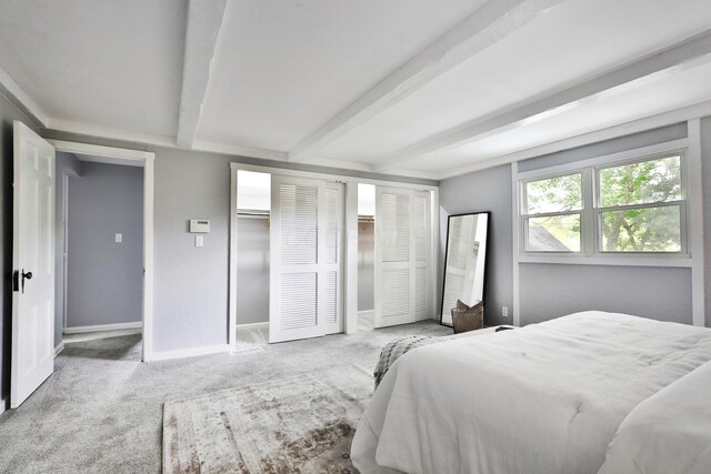 bedroom with beam ceiling, carpet, and baseboards