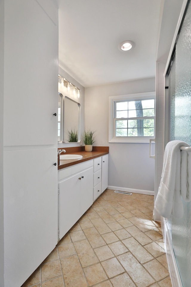full bathroom featuring vanity, stone finish flooring, and baseboards