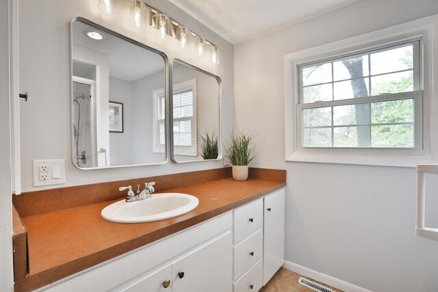 bathroom with vanity, baseboards, and tile patterned floors