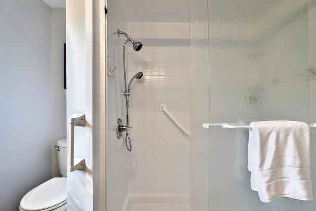 full bath featuring a stall shower and toilet
