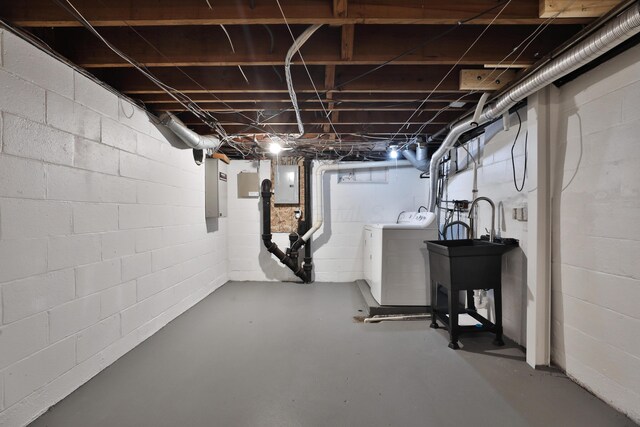 unfinished below grade area with washer and clothes dryer and electric panel