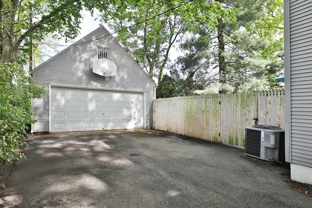 detached garage featuring fence and cooling unit