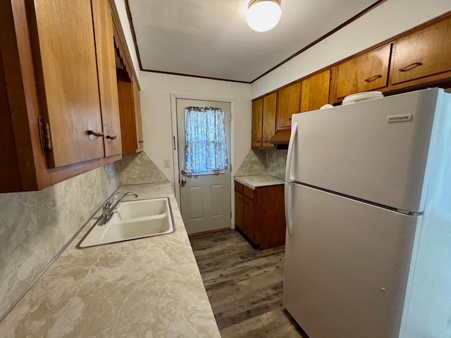 25 N Liberty St, New Concord, OH 43762 - kitchen featuring brown cabinets, a sink, tasteful backsplash, light countertops, and freestanding refrigerator