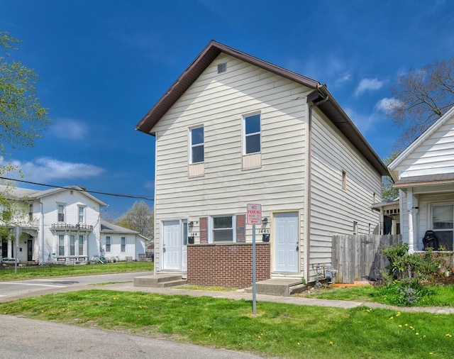 view of front of house featuring brick siding and fence