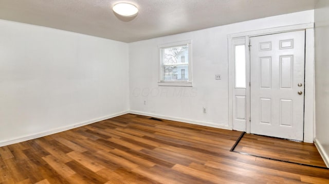 foyer entrance with baseboards and wood finished floors