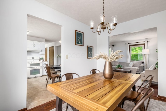 dining area with a chandelier and a textured ceiling