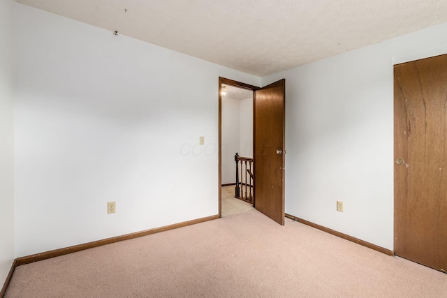 unfurnished bedroom featuring carpet flooring and baseboards