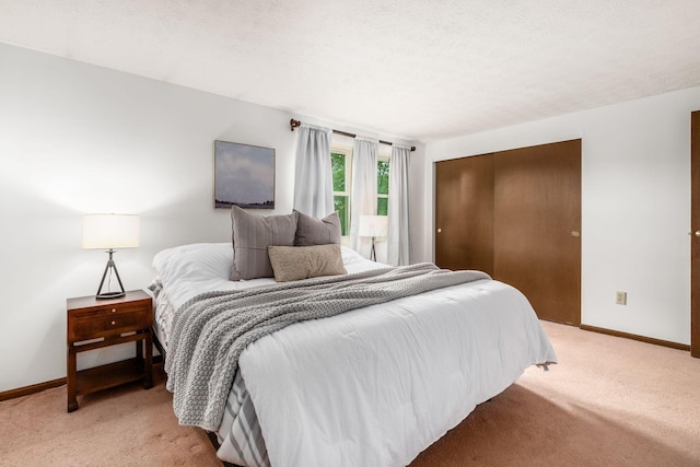 bedroom with light colored carpet, baseboards, and a closet