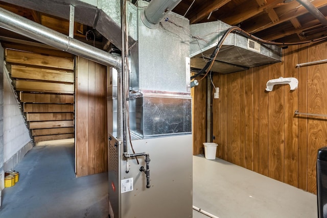 unfinished basement with wooden walls and heating unit