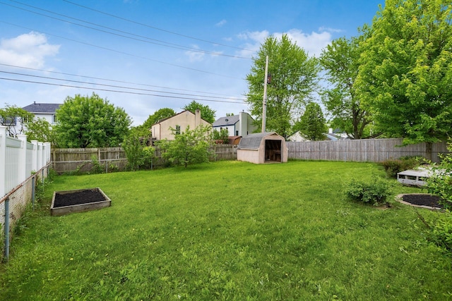 view of yard with a shed, an outbuilding, and a garden