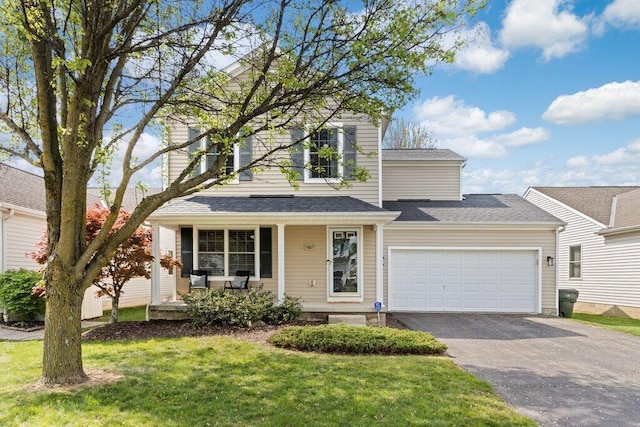 traditional-style house with a garage, a porch, driveway, and a front lawn