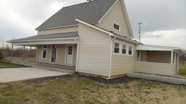 exterior space with roof with shingles and covered porch