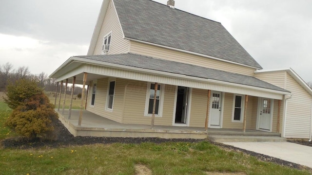 view of front facade featuring a shingled roof and covered porch
