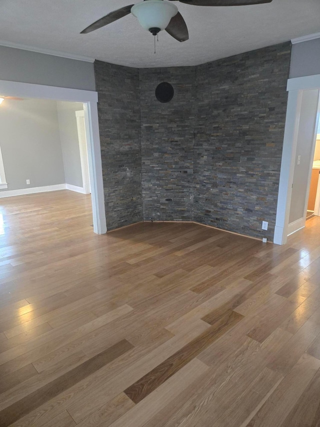 unfurnished room featuring wood finished floors, ceiling fan, and ornamental molding