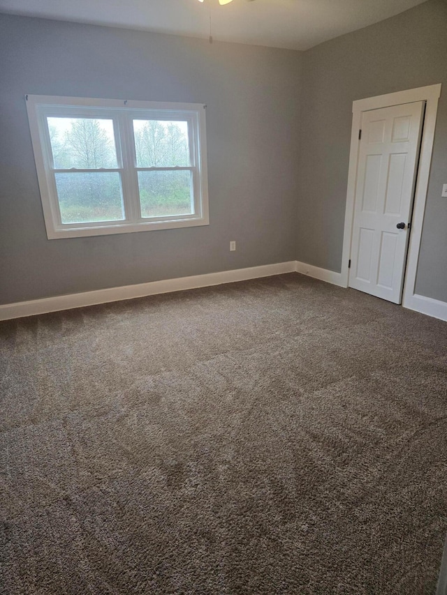 carpeted empty room with baseboards