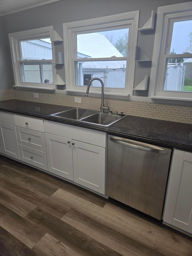 kitchen with stainless steel dishwasher, open shelves, dark countertops, a sink, and white cabinetry
