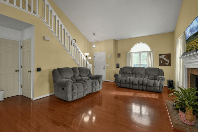 living area featuring baseboards, stairs, wood finished floors, and a fireplace