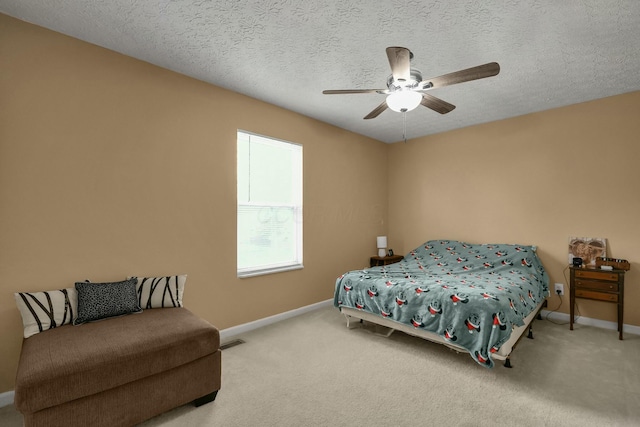 carpeted bedroom with a ceiling fan, baseboards, visible vents, and a textured ceiling