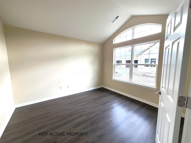 unfurnished room featuring visible vents, baseboards, vaulted ceiling, and dark wood-style floors