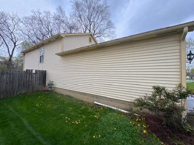 view of property exterior with fence and a yard