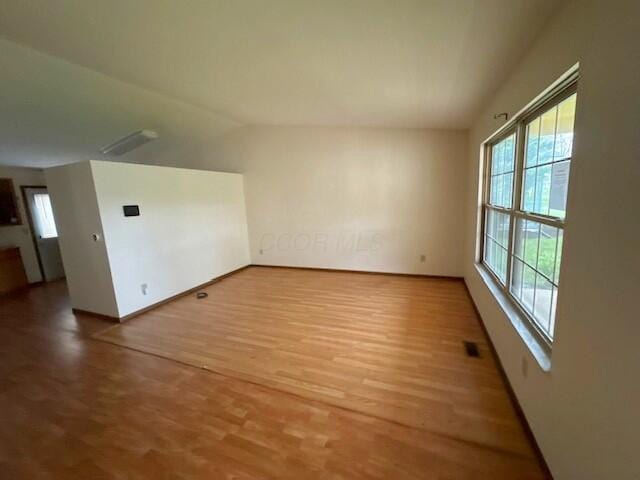 bonus room with lofted ceiling, wood finished floors, and baseboards