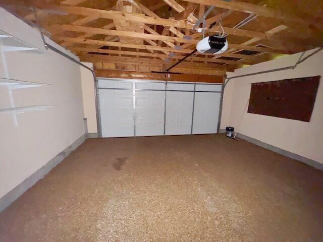 garage with a garage door opener and baseboards