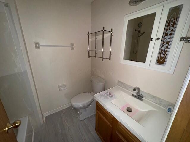 bathroom with wood finished floors, toilet, and vanity
