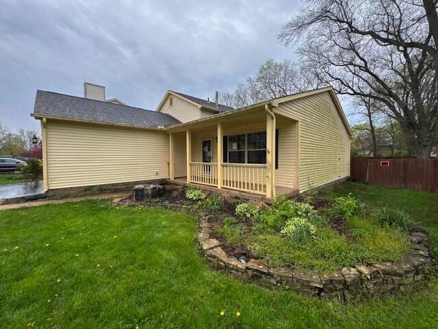 view of front of house featuring a porch, a front yard, and fence
