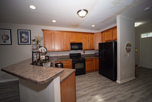 105 Autumn Ter SW, Etna, OH 43062 - kitchen featuring brown cabinets, a sink, a peninsula, light wood-type flooring, and black appliances