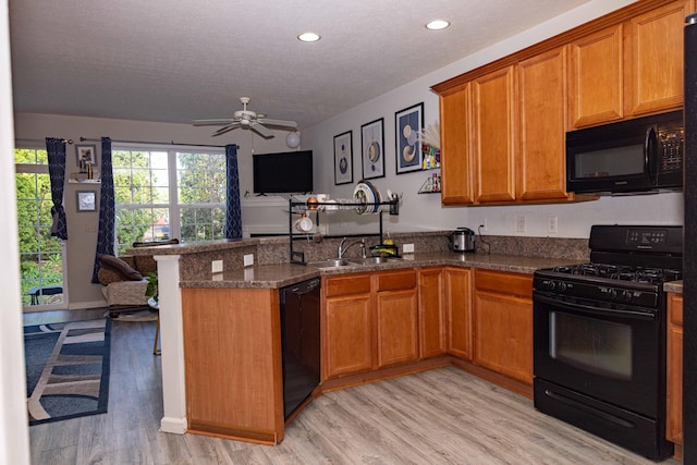 105 Autumn Ter SW, Etna, OH 43062 - kitchen featuring a peninsula, light wood-style floors, open floor plan, brown cabinets, and black appliances