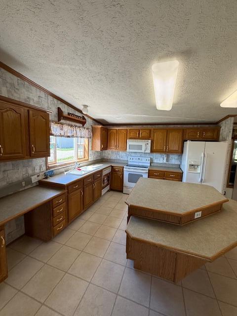 kitchen with brown cabinets, light tile patterned floors, crown molding, white appliances, and a textured ceiling