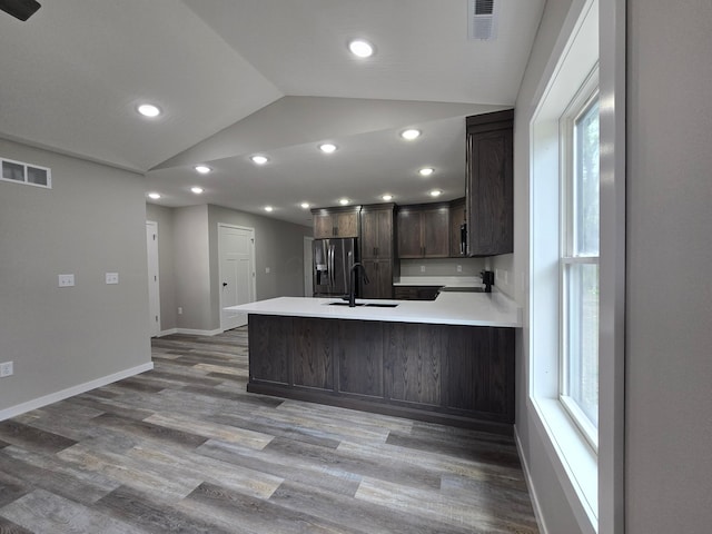 kitchen featuring a sink, stainless steel fridge, vaulted ceiling, and visible vents