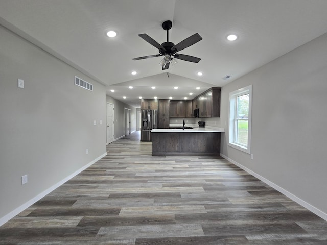 kitchen featuring visible vents, appliances with stainless steel finishes, dark brown cabinets, light countertops, and a sink
