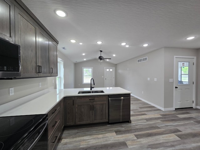 kitchen featuring a sink, a peninsula, wood finished floors, a ceiling fan, and dishwasher