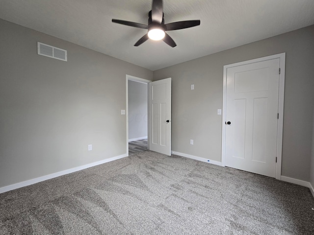 unfurnished bedroom with visible vents, carpet flooring, baseboards, and a ceiling fan