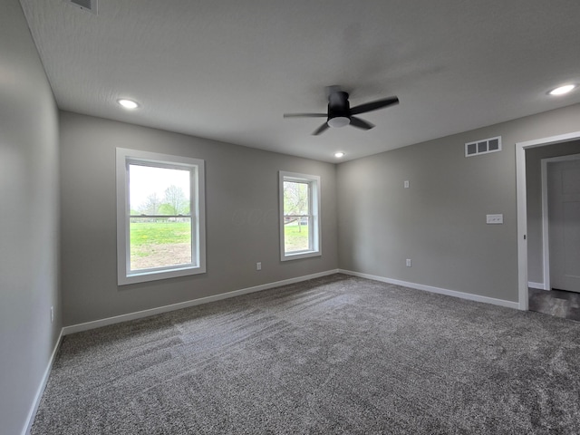 unfurnished room with visible vents, carpet flooring, baseboards, and ceiling fan