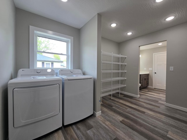 clothes washing area with dark wood-type flooring, washer and clothes dryer, baseboards, and recessed lighting