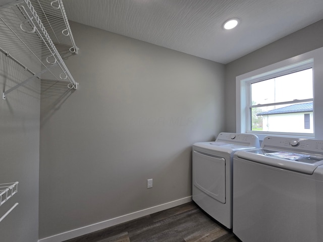 laundry room with laundry area, washing machine and dryer, baseboards, and dark wood-type flooring