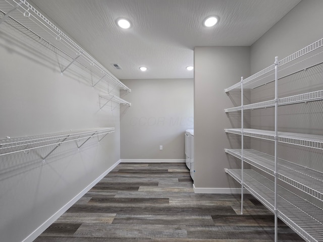 spacious closet with washer / dryer, wood finished floors, and visible vents