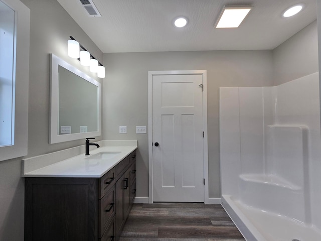 bathroom featuring walk in shower, vanity, recessed lighting, wood finished floors, and visible vents