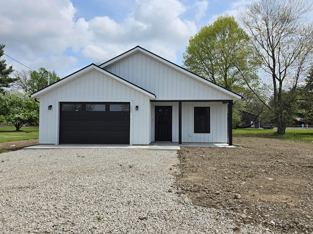 modern farmhouse featuring an attached garage and gravel driveway