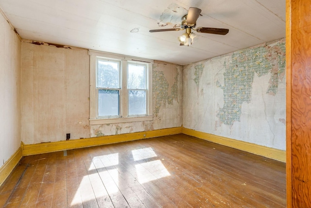spare room with hardwood / wood-style floors, baseboards, and ceiling fan