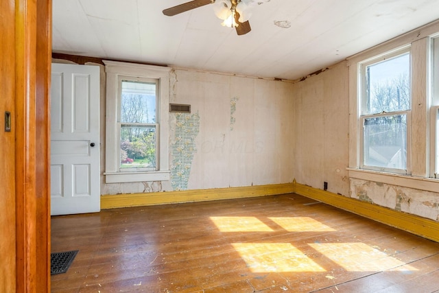 unfurnished room with hardwood / wood-style floors, ceiling fan, and visible vents